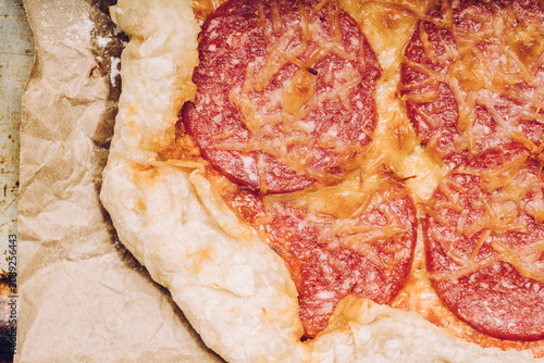 Homemade rustic pizza with sausage and cheese. Shot from above.