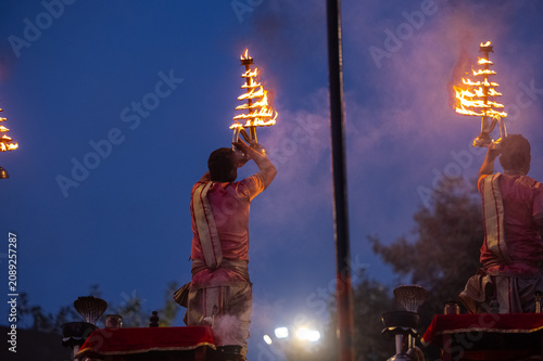 Ganga aarti, Portrait of an young unidentified male priest performing holy river ganga early morning aarti at assi ghat in traditional dress with hindu rituals.