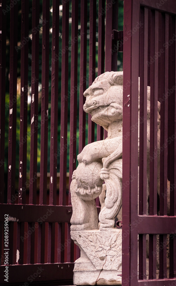 Obraz premium Weathered Lion Statue in Urban Setting