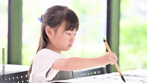 書道に集中して筆で文字を書く小学生の女の子・習字を学ぶ日本の子どものクローズアップの動画