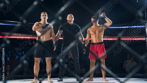 Konstfotografi MMA Fighters Fight Await the Fight Result in the Cage as the Referee Lifts One Hand to Declare the Winner