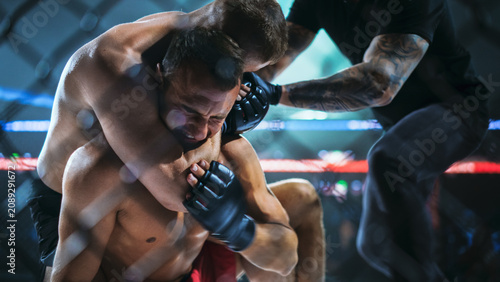 Foto MMA Fighters Fight on the Mat for a Submission as One Locks a Rear Choke Near the Cage
