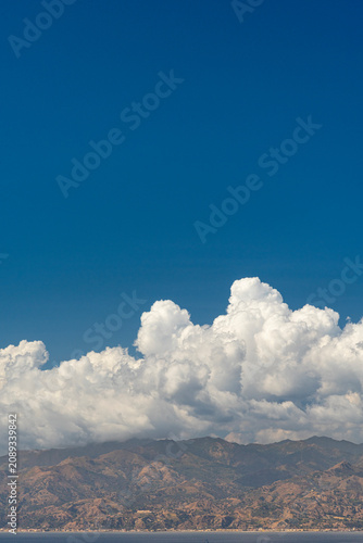 Formazione nuvolosa sovrastante le montagne limpide di Messina in verticale