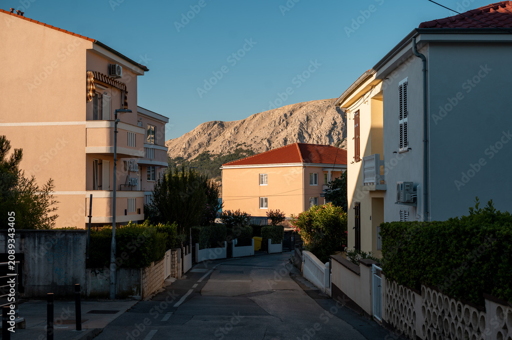 Obraz premium Idyllic Croatian coastal town street with Mediterranean architecture and mountains