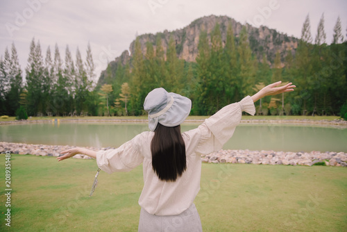 Woman in a cute outfit raise both hands looking at the mountains in Thailand.