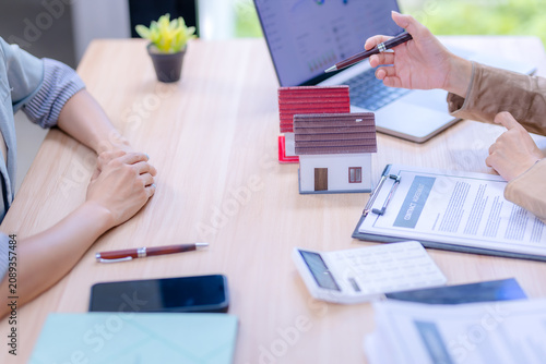 Cuadro en lienzo Real estate agent pointing at a laptop dashboard to explain housing loan trends and contract agreement details to a client