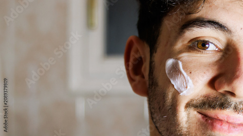 Man applying face cream, focusing on self-care and facial skin health