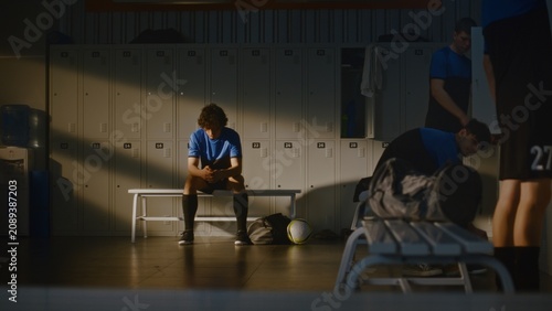 Fotografía While Rest of Youth Team Changing and Talking in Background, Coach Offers Words of Encouragement to Upset Boy