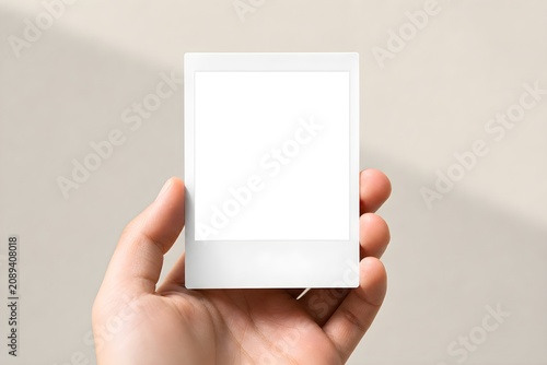 Blank Polaroid Photo Frame Mockup Held in Hand with Soft Natural Light. 