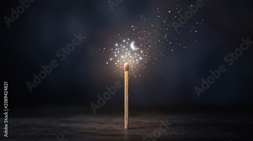 Matchstick with stars and a crescent moon glowing from its tip, concept of small sparks and big dreams