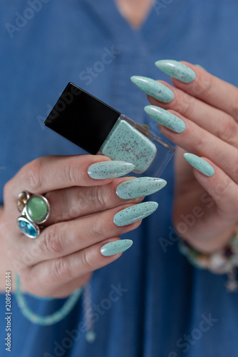 Canvastavla Female hand with long nails and light blue mint manicure