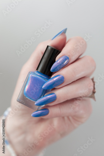 Woman's beautiful hand with long nails and light blue manicure 