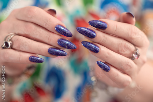 Female hands with long nails and purple manicure 