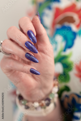 Female hands with long nails and purple manicure 