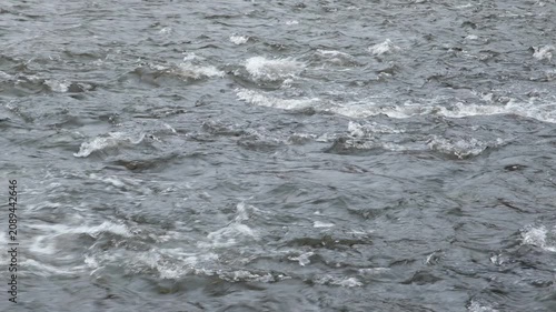 Mountain river, turbulent flow of water rolling over rocks, close-up video