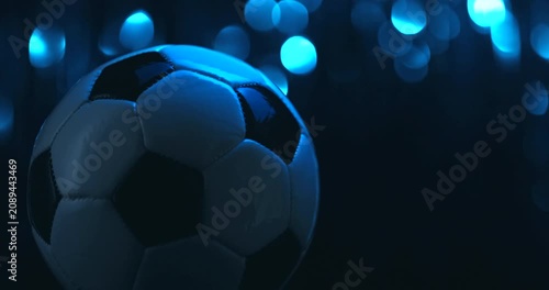 Rotating soccer ball close up on dark blue background