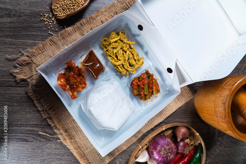 Obraz na plátně Lunch Box Delight: A visually appealing lunch box filled with an assortment of flavorful Indonesian dishes, artfully arranged for a delightful culinary experience