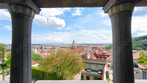 Foto panorama of Prague seen through the stone columns and windows in south gardens b