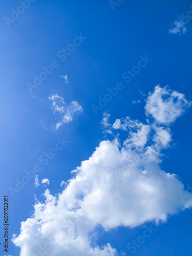 Clear Bright blue sky with fluffy white clouds, perfect natural background for summer designs, weather concepts, and peaceful outdoor projects. High resolution, clear daylight, nature photography