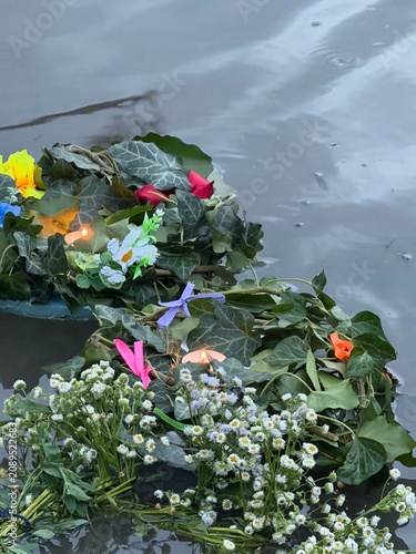 Traditional flower wreaths floating on calm water during the Ivan Kupala celebration. Peaceful summer evening scene with Slavic folklore, ritual traditions, and natural floral decorations.