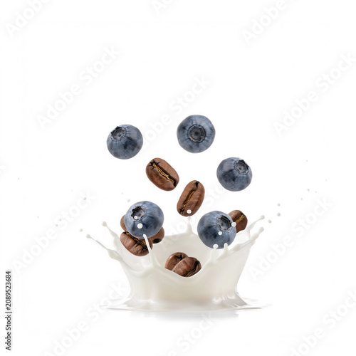 Fresh blueberries and roasted coffee beans splashing into milk during a studio shoot isolated on transparent background