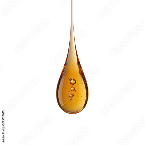 Golden honey drop falling with air bubbles during a macro shot with soft studio lighting isolated on transparent background