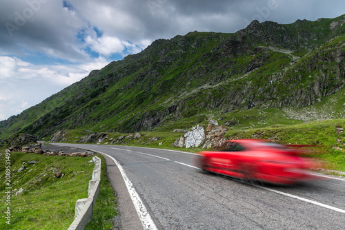 Red Car Driving on the Transfagarasan Highway in Romania