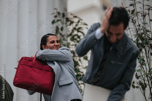 Canvastavla A businesswoman swings a red bag toward a man during a heated confrontation outside an office building