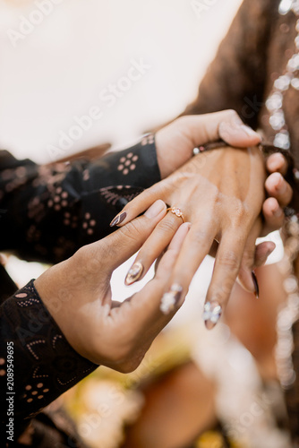 Two hands holding golden wedding rings in elegant gesture