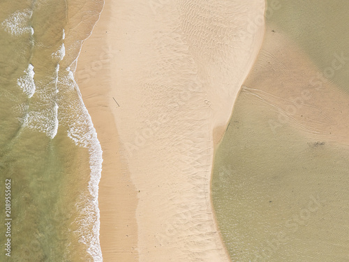 Captured from a drone directly overhead, the meeting of the turquoise sea and white sand makes for a stunning backdrop