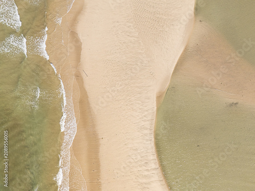 Captured from a drone directly overhead, the meeting of the turquoise sea and white sand makes for a stunning backdrop