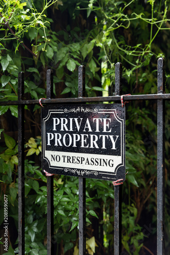 Obraz na plátne Private property no trespassing sign on a black metal fence