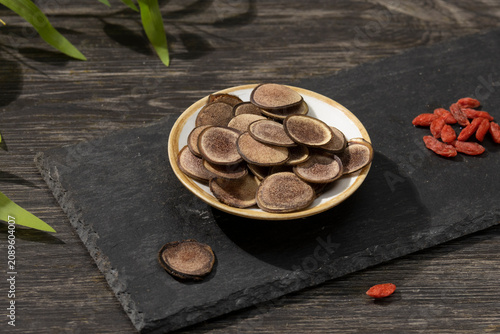 Cuadro en lienzo Slices of deer antler velvet in a ceramic bowl with goji berries on a black slat