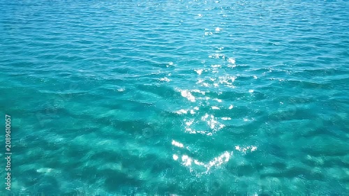 Shimmering Turquoise Ocean Water Surface with Gentle Ripples Reflecting Bright Sunlight in a Tropical Sea Background