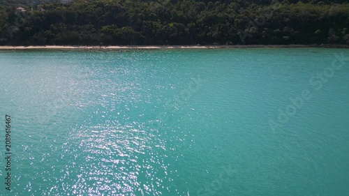 Aerial View of Turquoise Sea, Sandy Beach and Green Forest Coastline