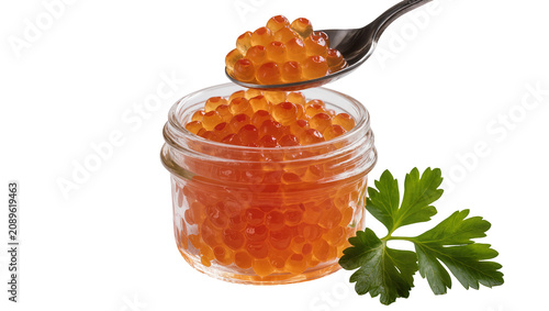 Fotografía Isolated red caviar in a glass jar with a spoon full of roe and a fresh parsley sprig