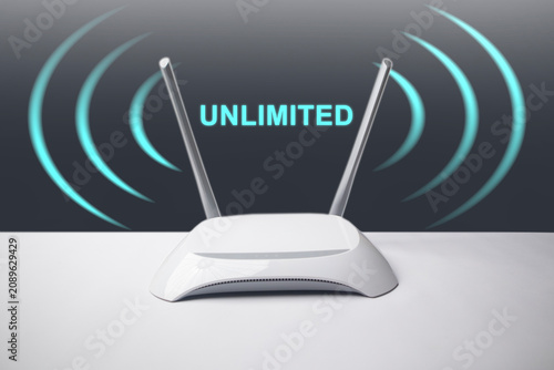 Canvas Print A conceptual image featuring a minimalist white wireless internet router with two antennas, surrounded by glowing blue signal waves and the overlay text UNLIMITED