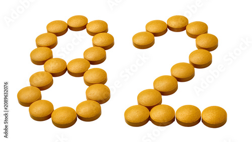 Obraz na plátně Isolated bright yellow round pills forming the number eighty-two, medical health