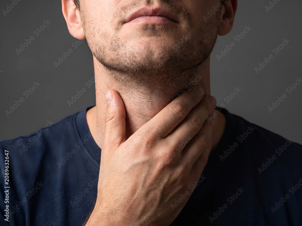 Fototapeta premium Man checking neck for thyroid enlargement or gland issues with swelling