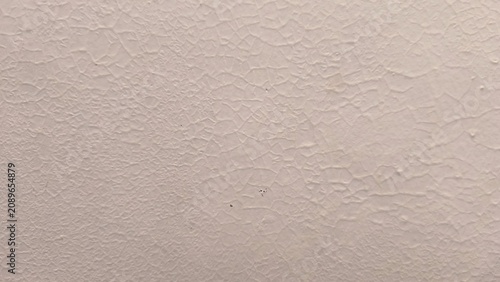 Fotografie Off white textured surface shows cracked paint pattern