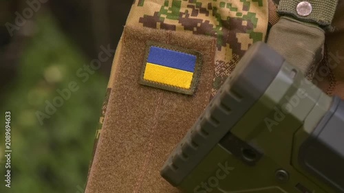 Close-up of the Ukrainian flag patch on a soldier's uniform sleeve. Symbol of national identity, military service, and the Armed Forces of Ukraine during the defense of the country's sovereignty and