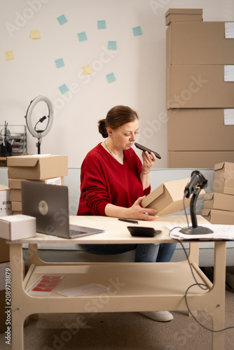 Konstfotografi Female small business owner using mobile phone checking parcel box