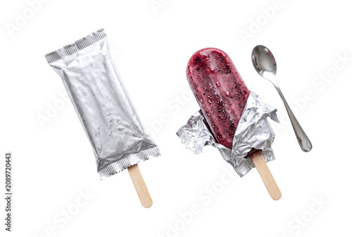 Obraz na płótnie Berry popsicle with foil packaging and spoon