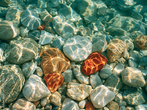 Coral reef colored stones under clear shallow water
