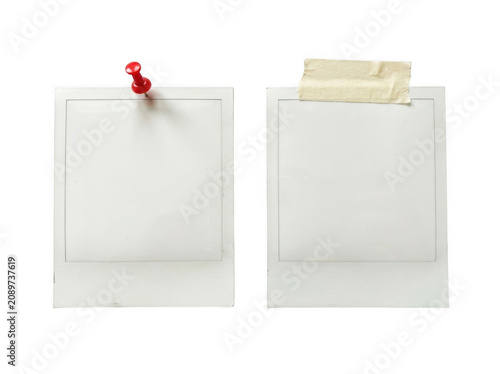 Two blank instant photo frames with a red pin and tape