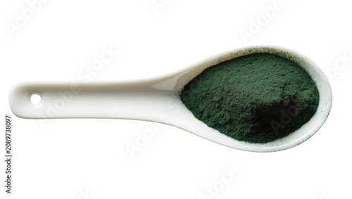 Isolated white ceramic spoon filled with healthy green spirulina powder, dietary supplement