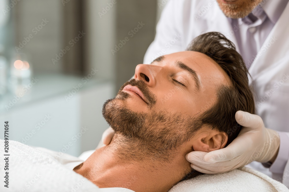 Fototapeta premium Man receiving professional facial massage at spa