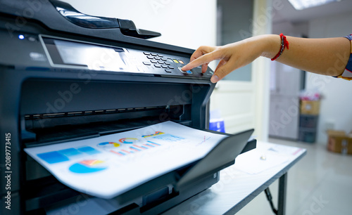 фотографія Office worker prints paper on multifunction laser printer