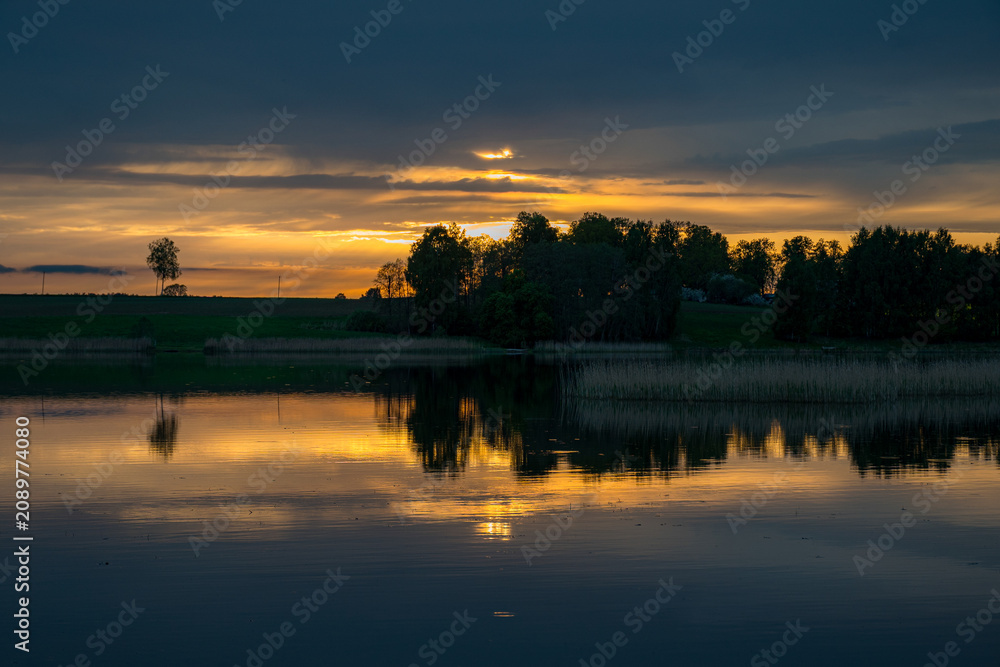 Naklejka premium beautiful sunset, sunrise landscape by the lake, reflections on the surface of the calm lake water, bright colors,
