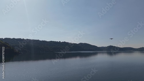 Aerial View of Firefighting Aircraft Flying Over Mountain Landscape